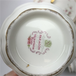 Paragon Victoriana Rose pattern tea and dinnerware, comprising fourteen teacups, sixteen saucers, fourteen side plates, two milk jugs, two open sucriers, two sandwich plates, a cake stand (lacking central support), two tureen and covers, eight dinner plates, twenty one dessert plates, eleven bowls, and sauce boat and stand. 