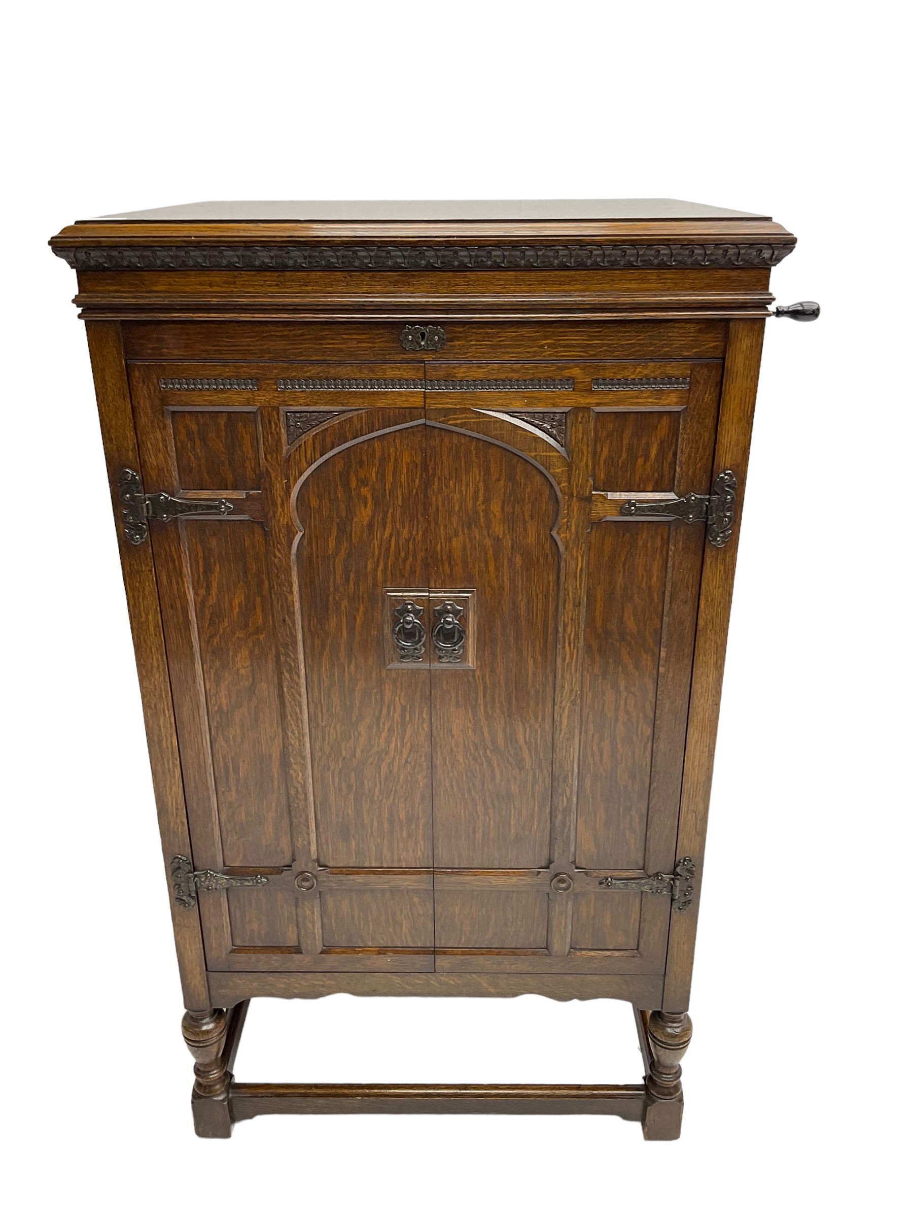Early 20th century ‘HMV' 202 cabinet gramophone, oak cased, moulded top with foliate carved moulding hinges to reveal gramophone, two doors enclosing horn, on turned supports joined by moulded stretcher rails