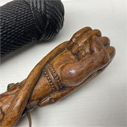 19th century wooden walking stick, the handle carved as a snake within a clenched fist, the cane carved with foliate and cross hatched decoration, with a metal spike to base, together with a turned wooden walking stick, with lacquered rope nautical knot handle, tallest L96.5cm