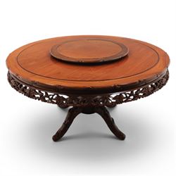 20th century Chinese ornately hardwood dining table and chairs, circular table with 'Lazy Susan' top with pierced carved frieze, raised on a quadriform base with carved foliate detail, the chairs en suite with carved pierced detailing  