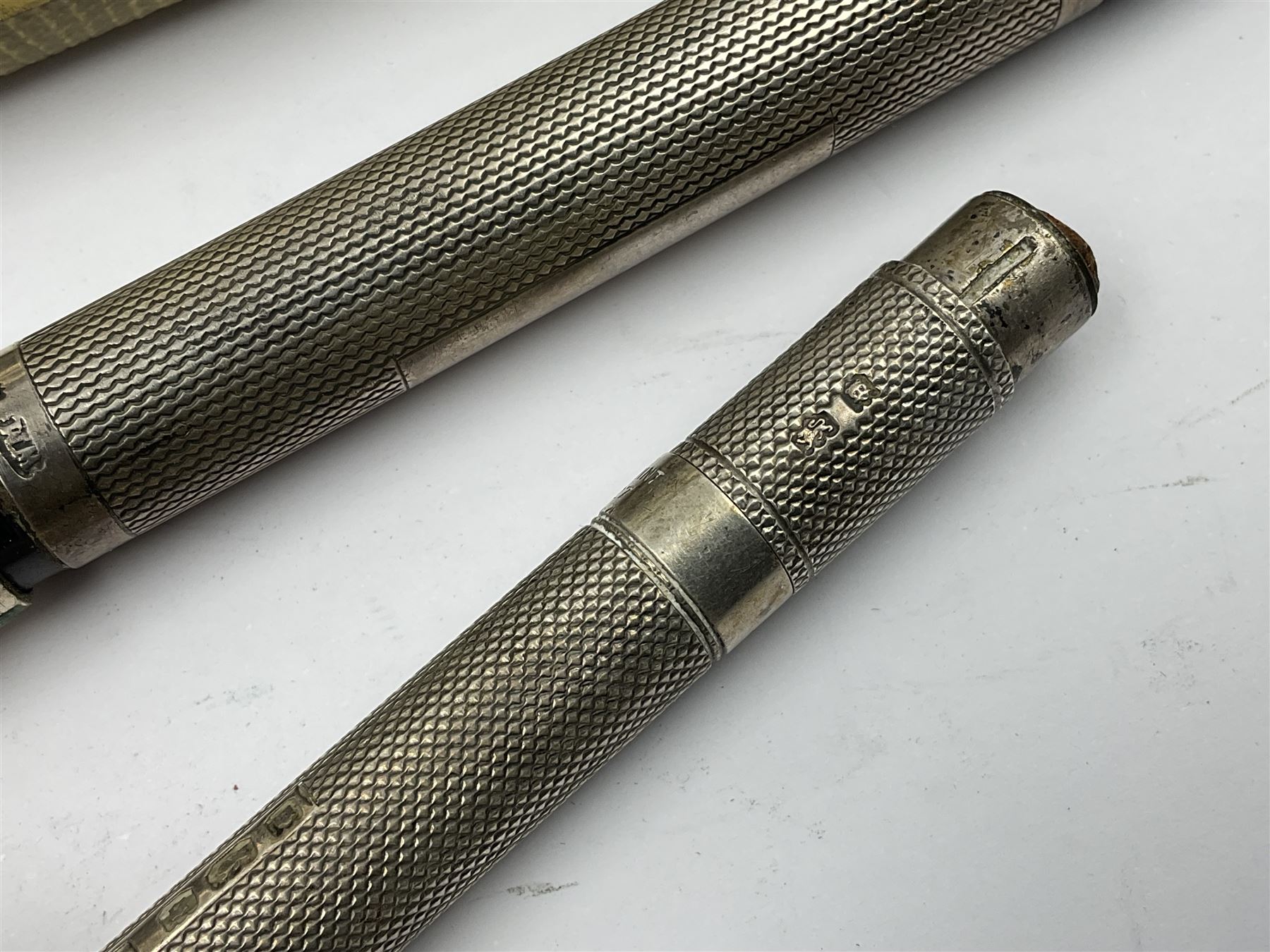 Three parker fountain pens, one example with 14ct gold plated cap and personal engraving, in Parker 51 box, together with a silver Sampson Mordan Everpoint propelling pencil with personal engraving and a silver cased fountain pen with 14ct gold nib and a souvenir bronze Dollfus-Mieg medallion, awarded to John G Sedorski, in fitted case 