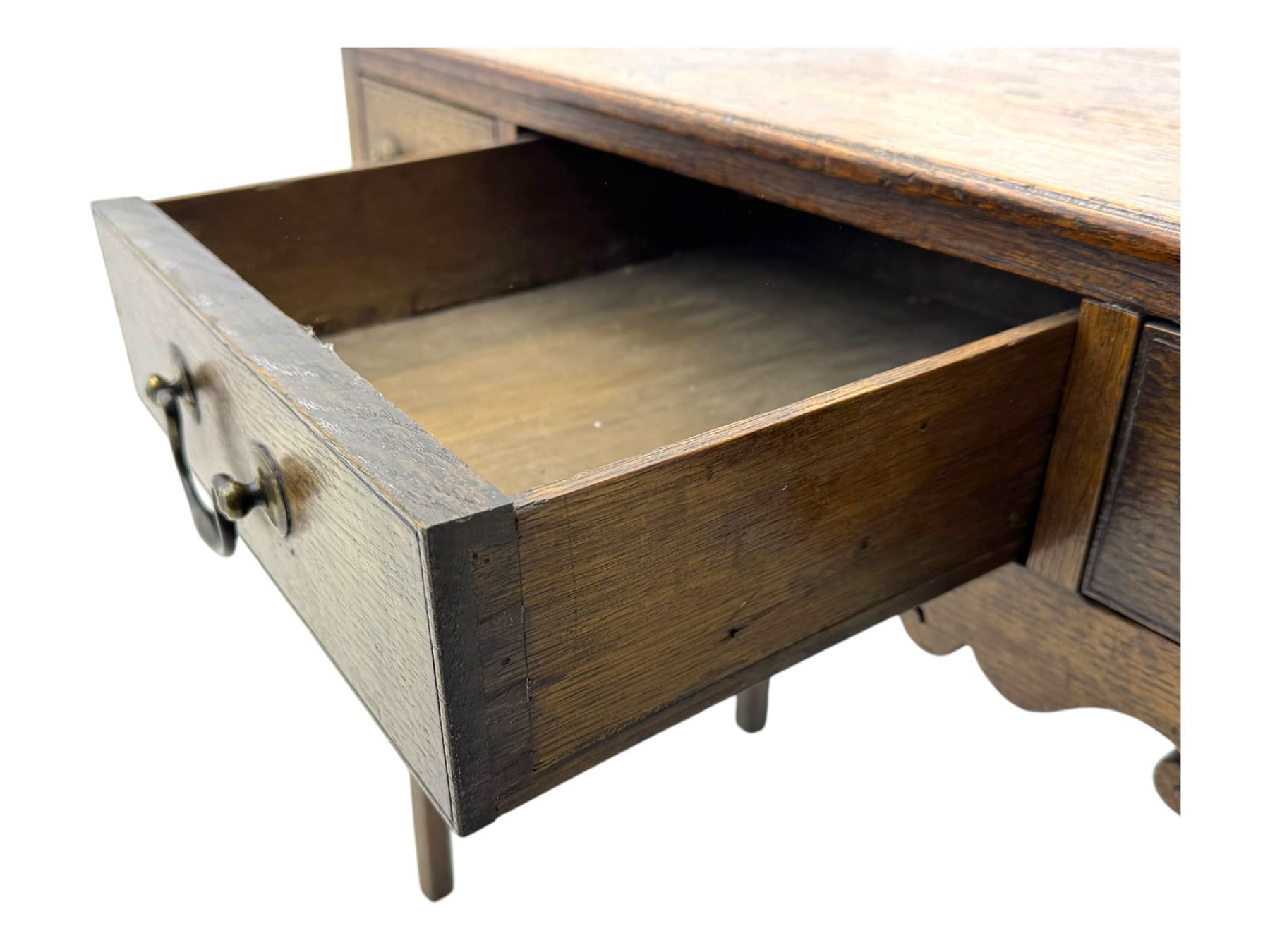 18th century oak lowboy, rectangular moulded top over three frieze drawers with brass swing handles, scalloped apron, on slender square section supports