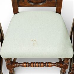 Country House oak high back dining chairs, set of ten comprising eight side chairs and two carvers, each with arched top rail flanked by turned finials over a central fielded panel back, with overstuffed seats upholstered in pale fabric, raised on turned front supports united by stretchers