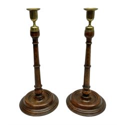 Pair of George III style oak candlesticks, each with fluted brass socket with removable brass nozzle, upon a tapering column and turned circular stepped foot, H38cm 