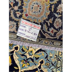 Central Persian Kashan hand-knotted carpet, the navy field with central medallion in pale blue and gold tones, surrounded by spiralling arabesques and palmettes, framed by quarter spandrels and a wide border of stylised lotus and rosette motifs between floral guard stripes, from the region of Kashan