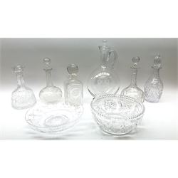 Large modern clear glass decanter or claret jug, of bulbous form with curved handle to the tapering neck, stopper with ball finial, and etched decorated depicting a crowned coat of arms to one side, and flowering basket to the other, H37cm, together with two Stuart Crystal bowls, and a group of five glass decanters of various form. 