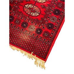 Persian design red ground runner, the field decorated with repeating Boteh motifs, five-band border (277cm x 74cm); Bokhara design red ground rug, decorated with a single row of Gul motifs (272cm x 69cm)