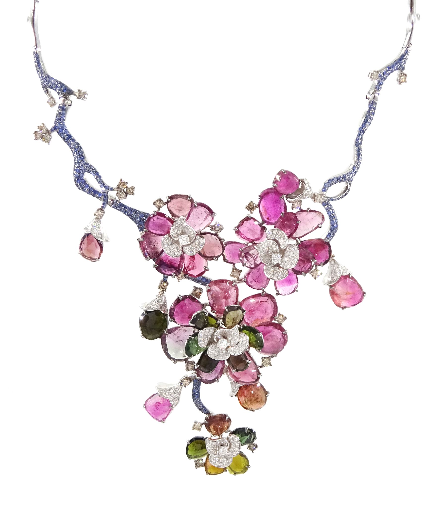 18ct white gold gemstone set floral jewellery suite, comprising necklace, pair of earrings and bracelet, each with tourmaline flower petals, round brilliant cut diamond centres and sapphire stems, stamped