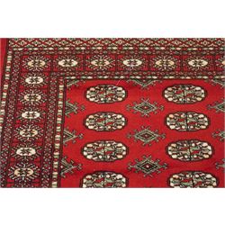 Two Afghan Bokhara crimson ground rugs, the fields decorated with repeating Gul motifs with geometric guard bands (126x190 & 157x250)