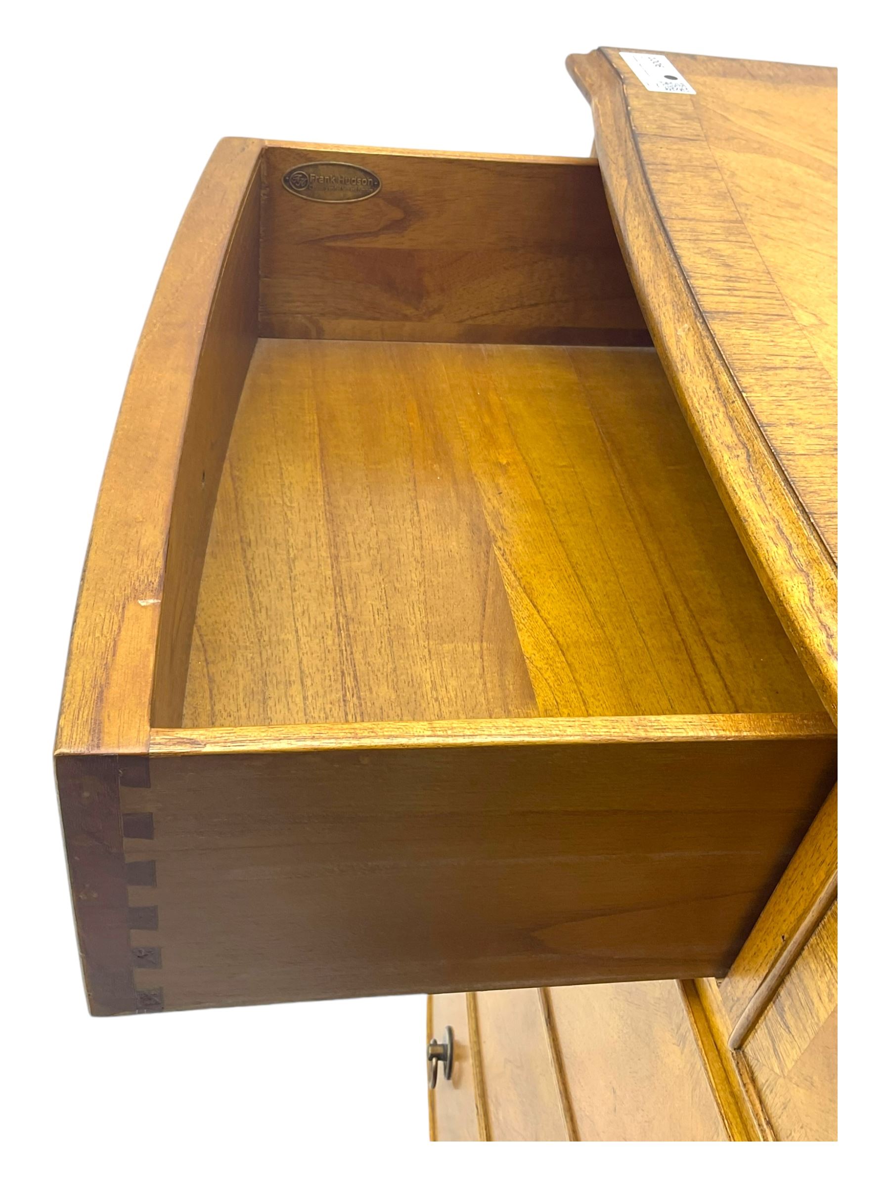 Frank Hudson - mid-20th century Mindi ash and burr walnut 'Spire' bow-fronted chest, featuring a crossbanded top over two short and three long cockbeaded drawers, raised on turned supports  