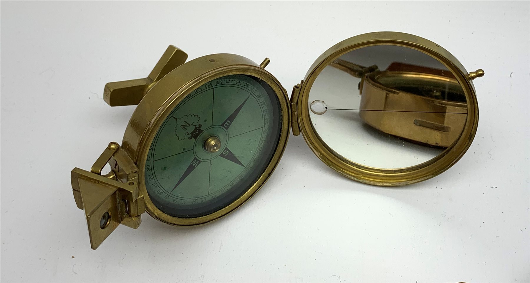 Brass Natural Sine type compass with spirit levels to the dial, bears name of Stanley, D8cm, in earlier mahogany box; brass pocket sextant of drum shaped form, the screw top marked Stanley London; small brass cased compass with pedestal tripod base; and Glass Developments Ltd. hahogany and brass spirit level L31cm (4)