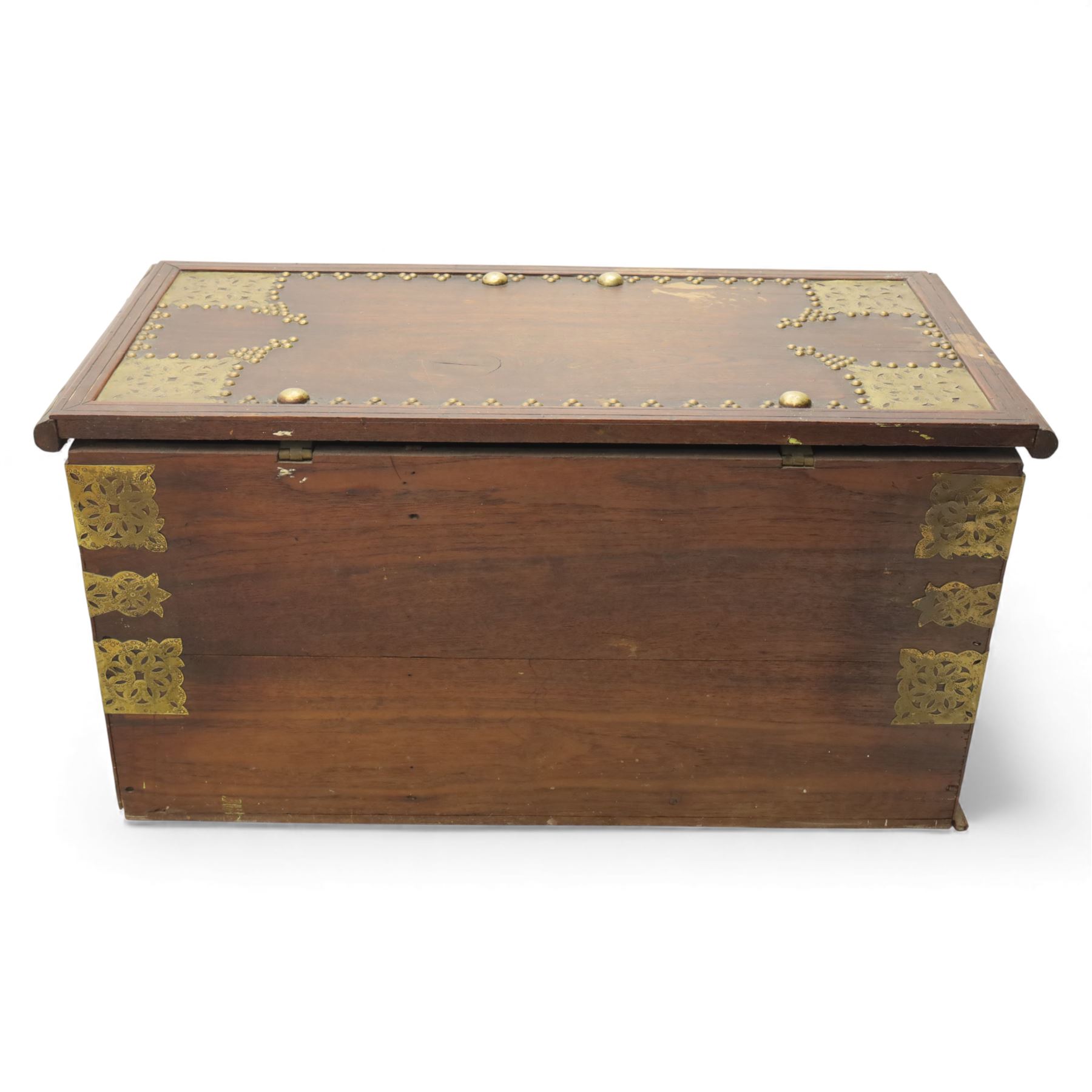 Early 20th century brass-mounted hardwood chest, the hinged top and front richly decorated with applied and studded brass panels and pierced lock escutcheon, revealing a candle box, reinforced with brass corner mounts