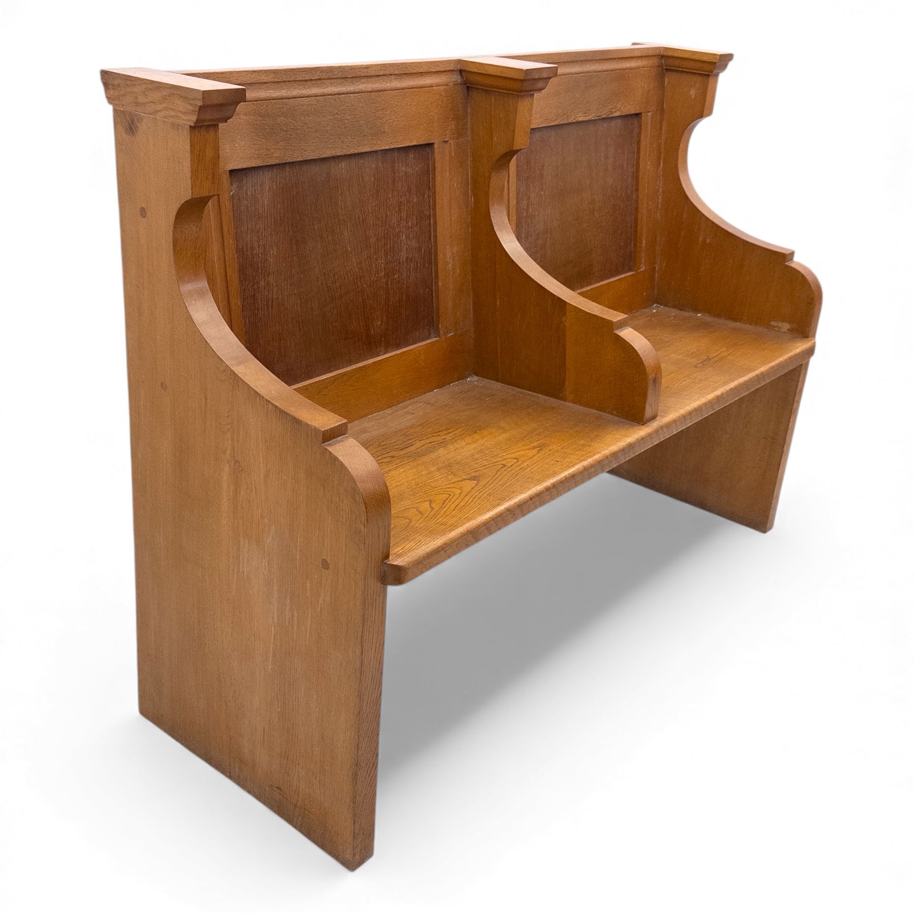 Pair of mid 20th century oak ecclesiastical pews, each with panelled backrests and shaped end supports, of solid construction and mellow honeyed tone
