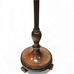 20th century mahogany standard lamp, with fluted tapering column above a turned and moulded circular base, standing on three short bracket supports