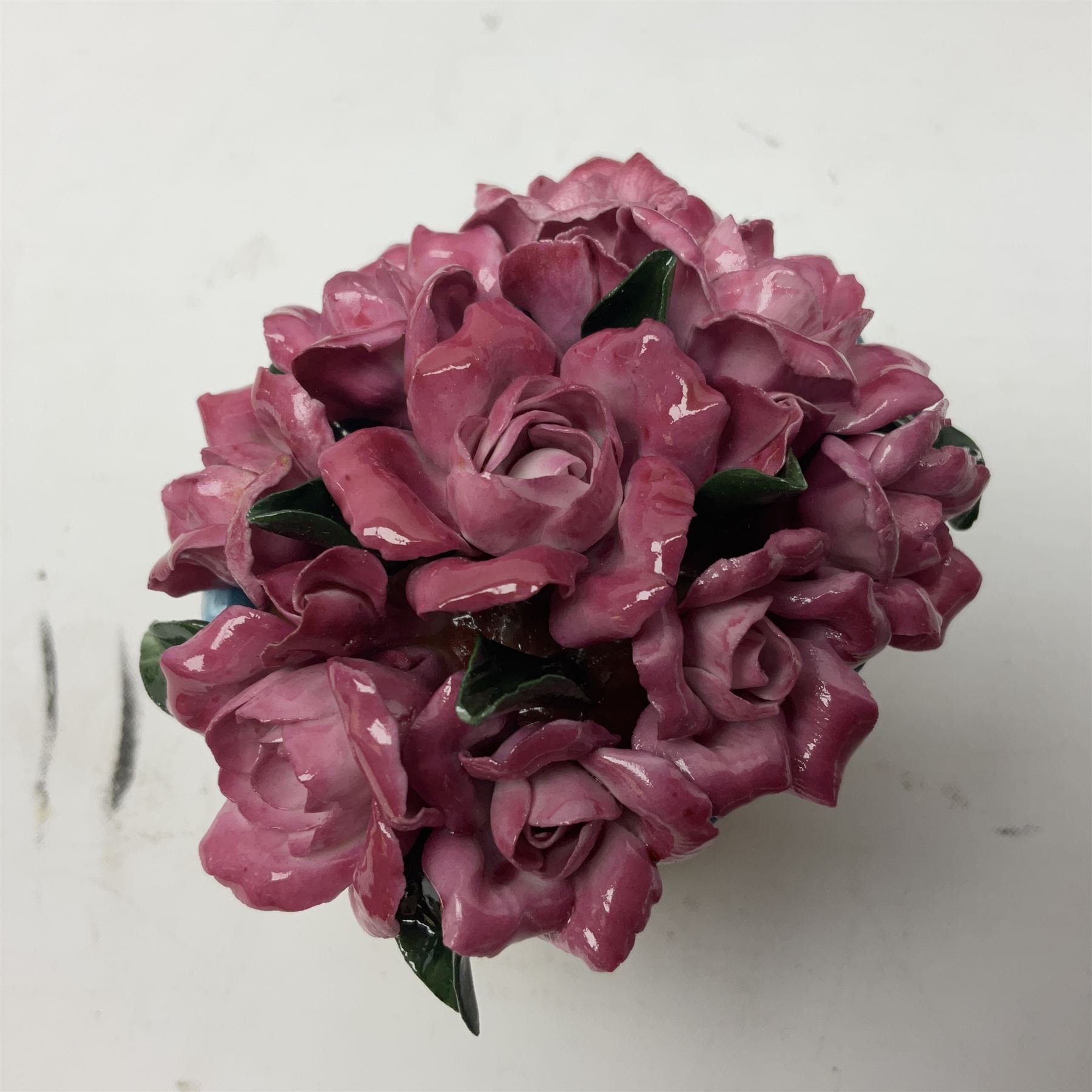 Halcyon Days bonbonniere, modelled as pink roses in a planter painted with a blue and white Japanese scene, together with five Halcyon Days enamel boxes, one a larger example depicting 'The Becket Casket' and four smaller boxes, including The 1993 Easter Egg, Happy Birthday and Statue of Liberty examples, all boxed, Becket Casket D8cm