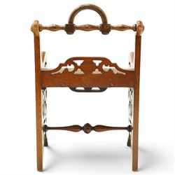 Late 19th century Gothic Revival carved oak hall chair or window seat, the swell-turned top rail centred by an arched carrying handle, over shaped open arms and solid plank seat, with pierced and carved scrolling foliate fretwork side panels and apron with applied central roundel, raised on shaped supports united by turned stretcher