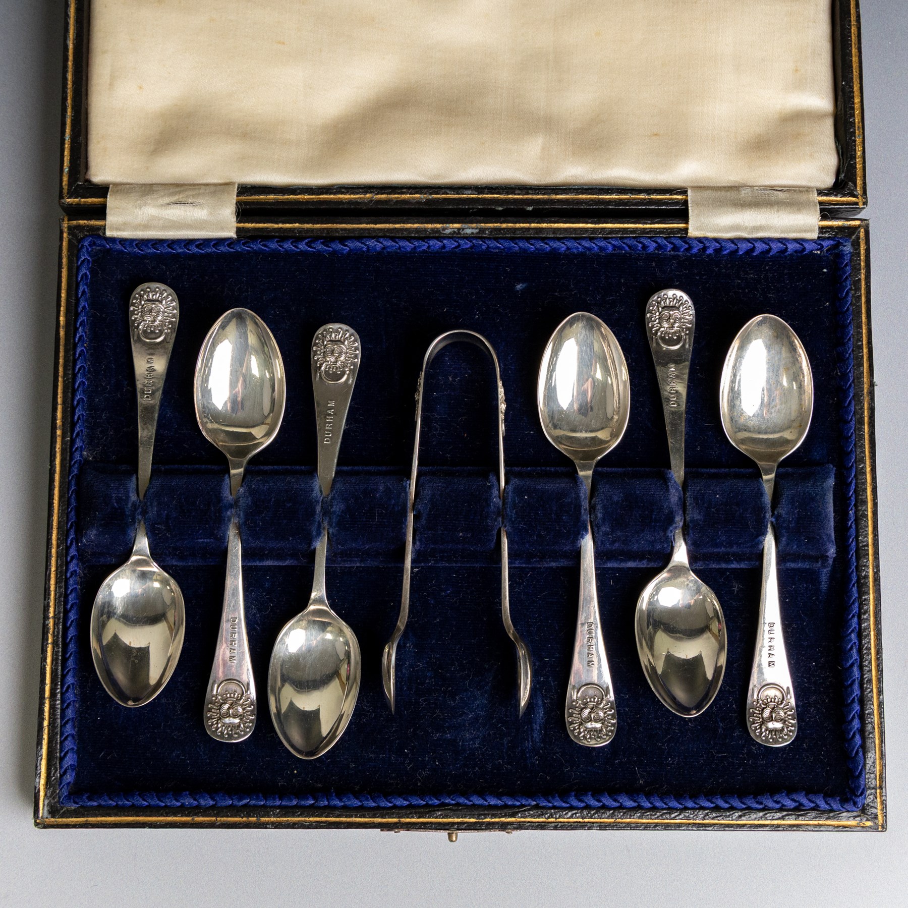 Set of six 1920s silver teaspoons and pair of sugar tongs, each decorated in relief with the Durham Cathedral sanctuary knocker and with rattail bowls, hallmarked Cooper Brothers & Sons Ltd, Sheffield 1923, contained within a fitted case