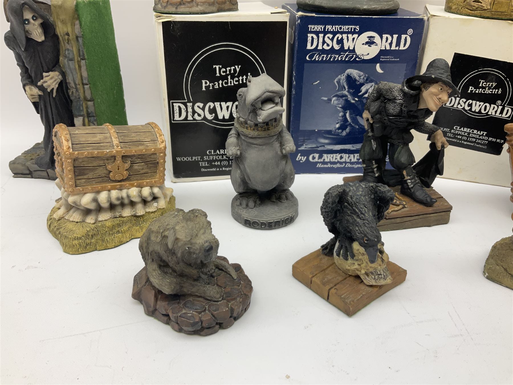 Terry Pratchett Discworld figures, comprising Roderick the hippo, DWE2, a 1995 event piece, Rincewind bookend, DW11, Death bookend, DW12, Librarians wizard knob, boxed, DW55, the luggage, boxed, DW04, tankard from the mended drum, DW21, Teppic the assassin, DW32, Greebo, DW45, Herne the hunted, DW64, Gaspode,  DW31, Quoth on skull, DW49 and Dibbler's compass DW16. 