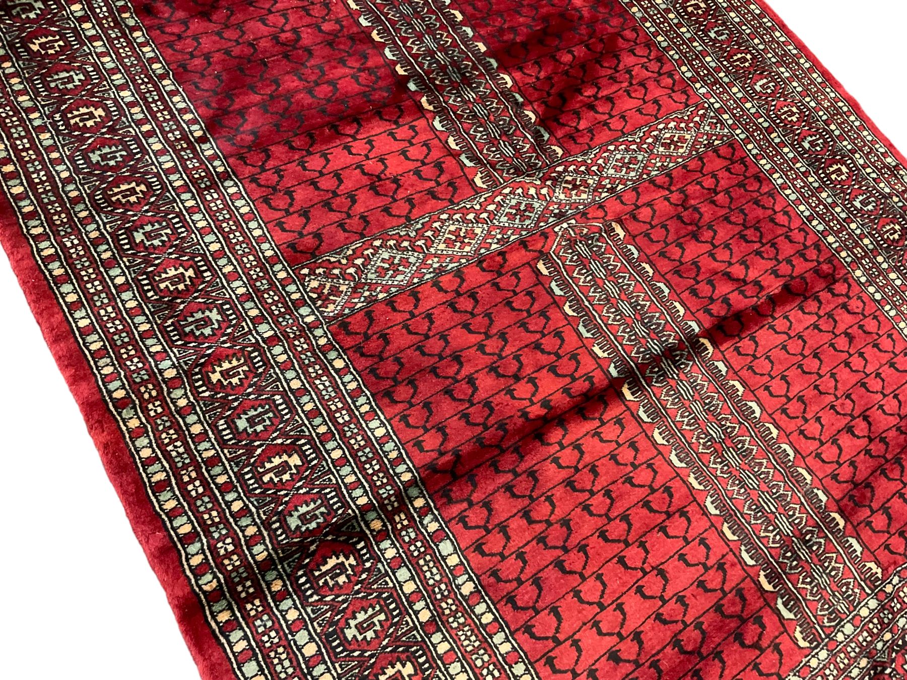 Tekke Ensi crimson ground rug, the quartered field decorated with candelabra motifs, multi-guarded border with repeating geometric hexagonal lozenges in blue and ivory