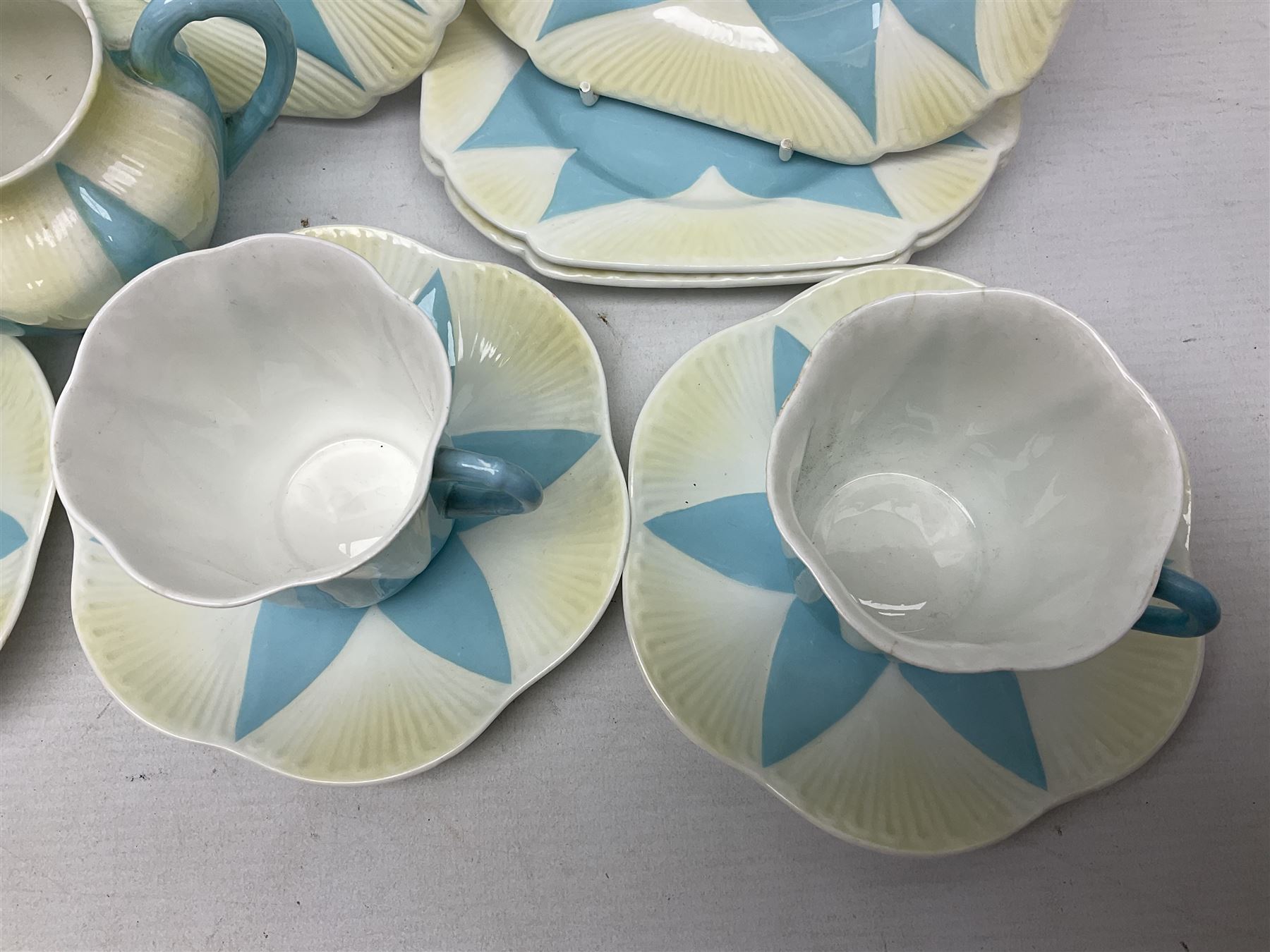 Shelley Dainty pattern tea wares, of lobed form with blue star decoration on merging white and yellow ground, comprising five teacups, five saucers, six tea plates, milk jug and cake plate, all with printed green mark beneath, some with painted pattern no 11770