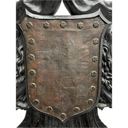 Grand mid-to-late 19th century heavily carved beech framed throne chair, the crown pediment carved with flower heads and cross finial, scroll and acanthus carved upright supports with twin perching griffin back enclosing etched leather work heraldic shield with castle and lion motifs over splayed feathers, flower head carved down sweeping arms with grotesque carved terminals, the seat rails carved with further flower heads on moulded supports with oversized ball and claw carved feet

Provenance: A very similar chair was used in the filming of Stanley Kubrick's 'Eyes Wide Shut' (1999)
