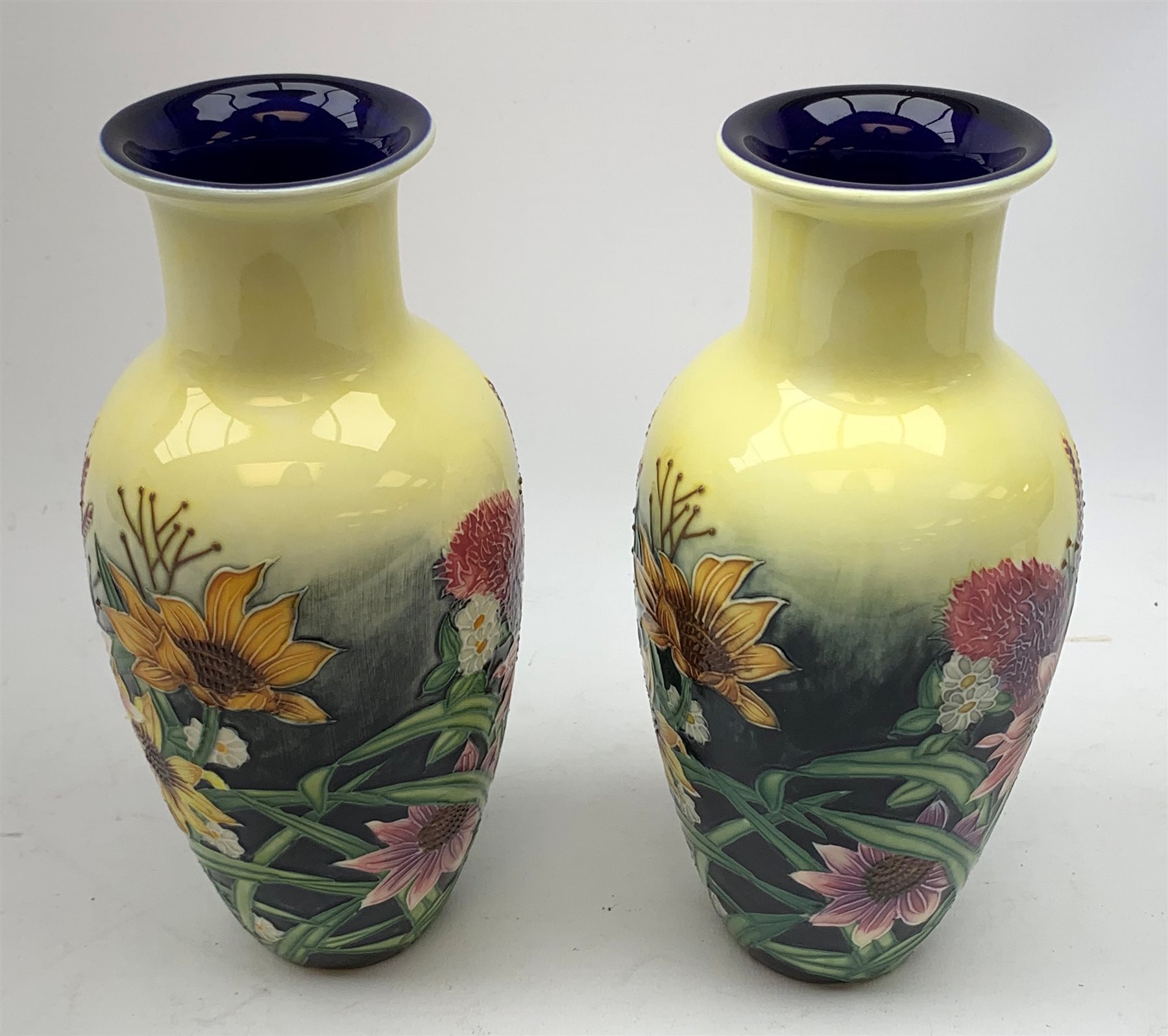 An Old Tupton Ware honey pot, of oval form with tube lined tendril decoration, the domed cover surmounted by a honey bee, with accompanying spoon, together with a pair of Old Tupton Ware vases, with tube lined sunflower decoration, H22cm, each with printed mark to base.