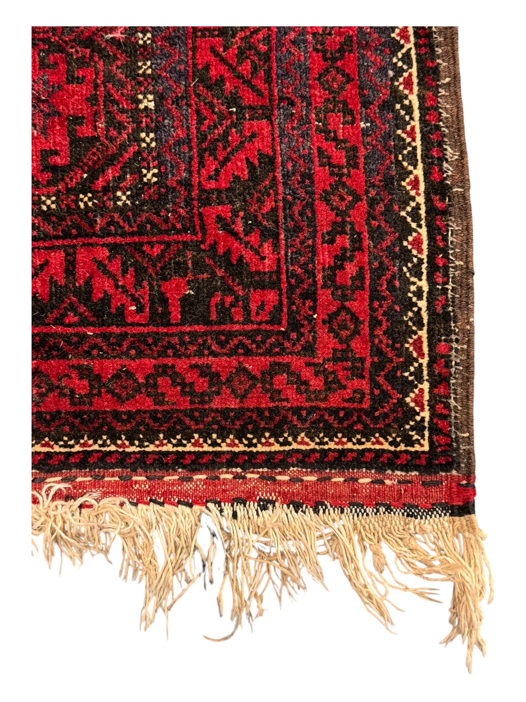 Turkoman red ground wool rug, the field with a repeating pattern of Tekke gul motifs in dark brown and red (195cm x 98cm); Afghan Bokhara red ground wool rug, central field with repeated geometric octagonal gul motifs, surrounded by multiple borders with stylised diamond and triangular patterns (127cm x 181cm)