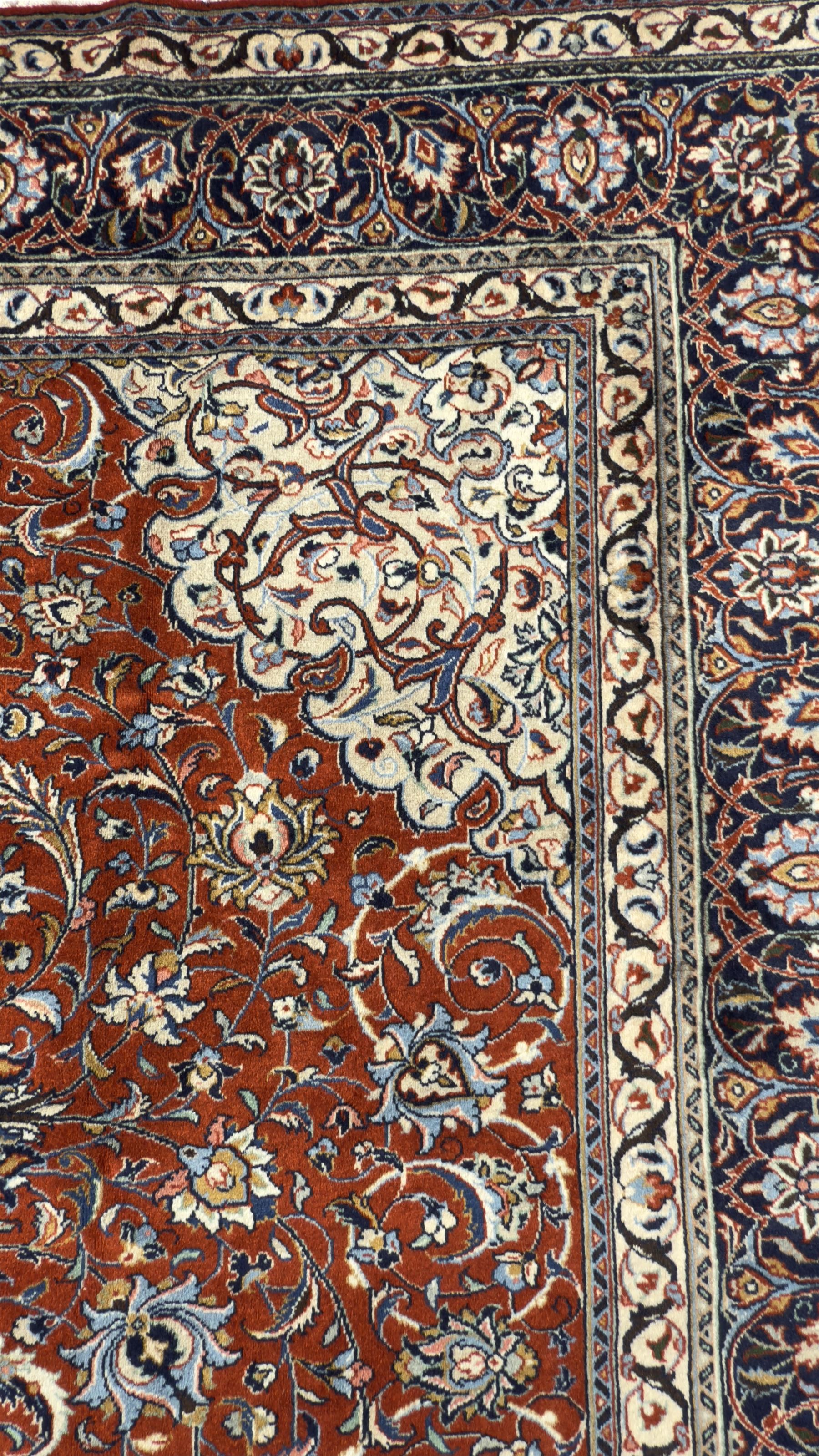 Central Persian Sarouk dark indigo and crimson ground rug, the medallion, field and spandrels decorated with repeating floral Herati motifs, the border decorated with scrolling branches and palmettes with small floral motifs, floral pattern guard stripes