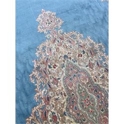 Large Persian design carpet, plain light blue field with floral design central medallion, scrolling foliate spandrels and borders decorated with flower heads