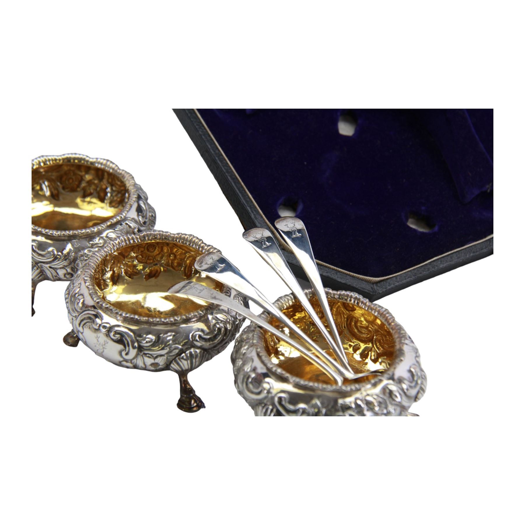 Cased set of four Victorian silver open salts, each of cauldron form with embossed foliate decoration, gadrooned rim and gilt interior, upon three hoof feet, hallmarked William Hunter, London 1844, H4cm, together with four earlier Georgian salt spoons, hallmarked London 1800, makers marks worn and indistinct, contained within a fitted case with velvet and silk lined interior
