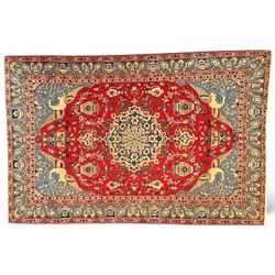 Central Persian Isfahan carpet, central ivory medallion with scrolling floral motifs on a ...