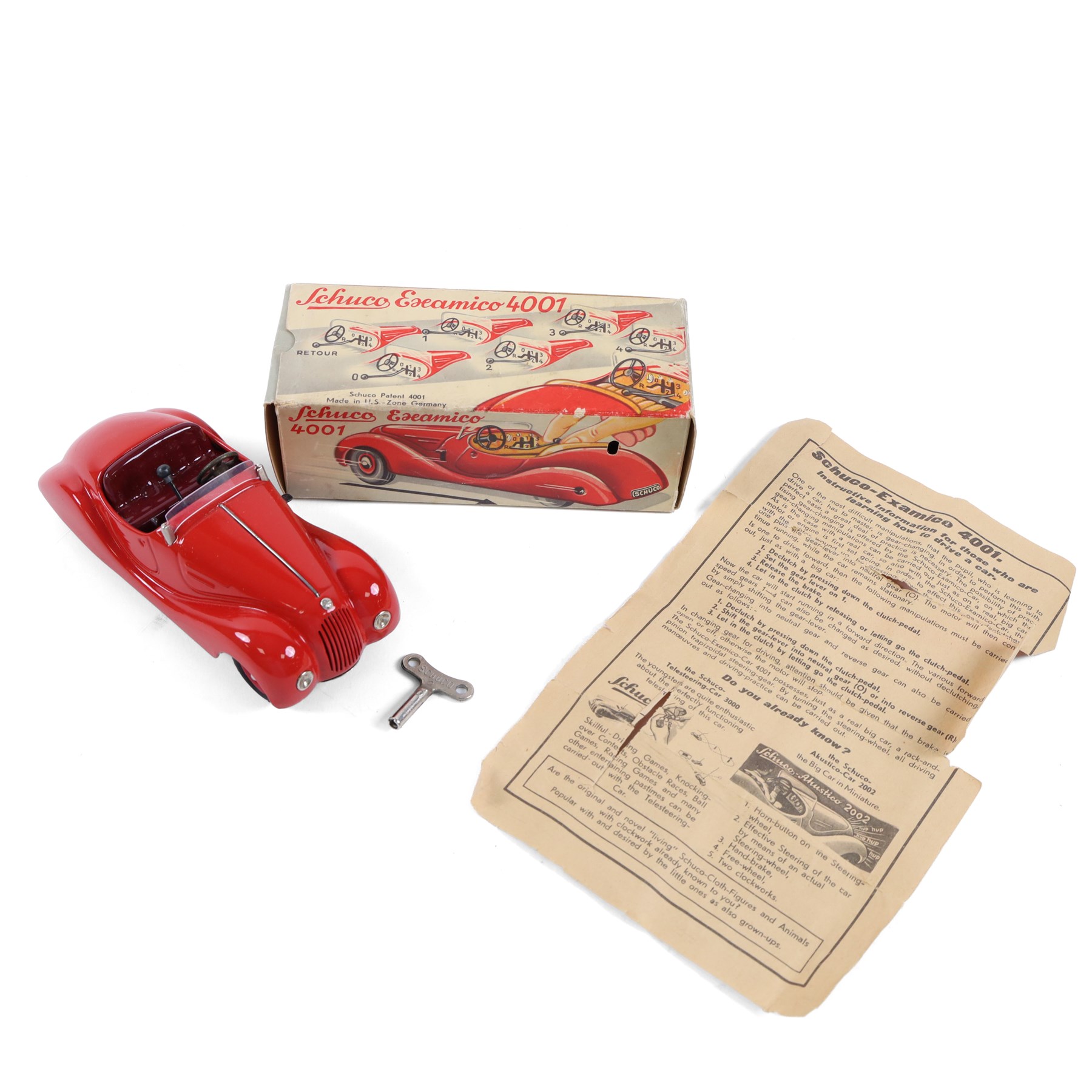 Schuco Examico 4001 tinplate clockwork car, in red with burgundy interior, with key and instructions, boxed