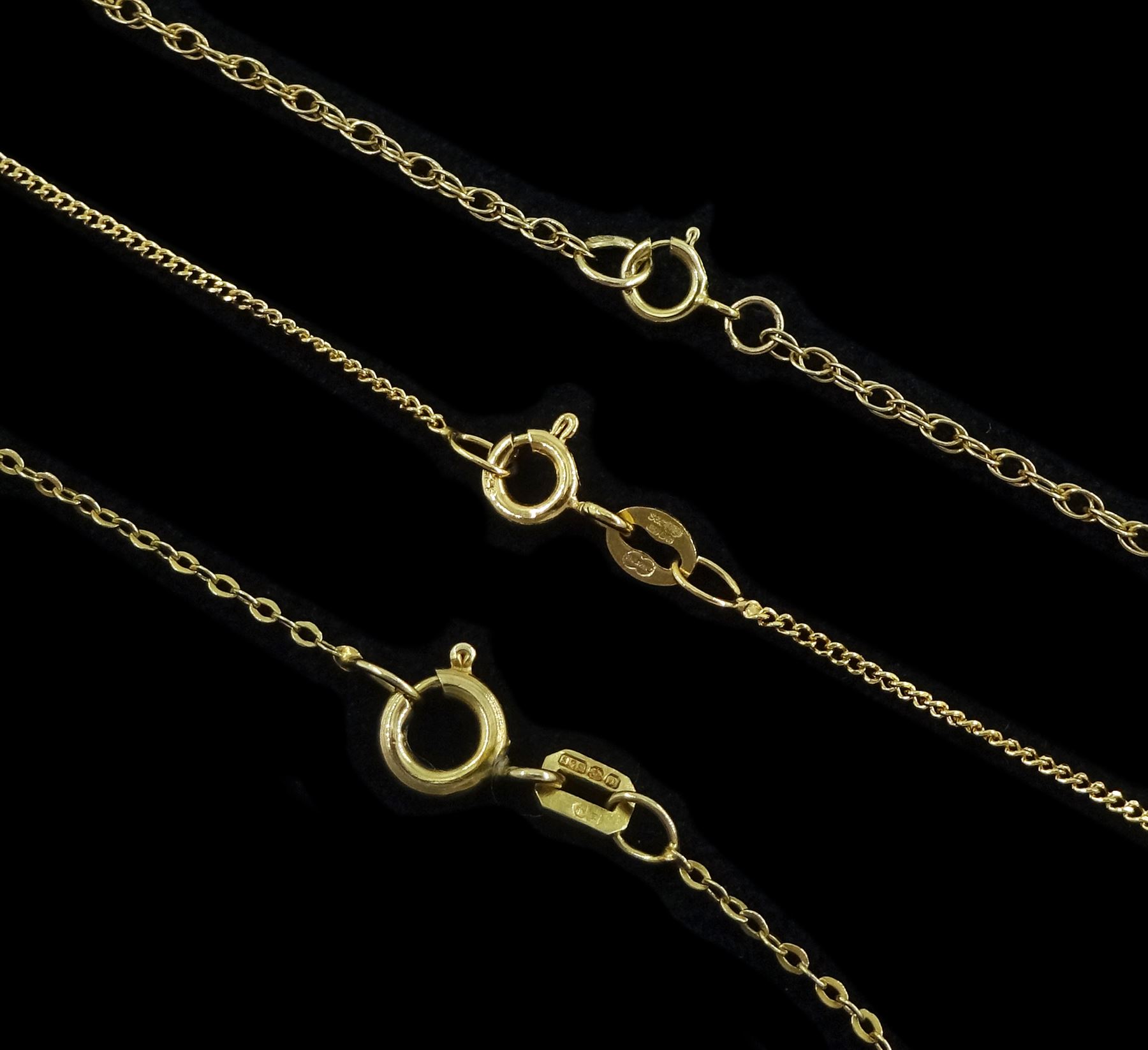 Three early 20th century 9ct gold cross pendants, with engraved decoration, on later 9ct gold chain necklaces