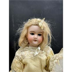 Two German bisque head dolls, to include a Franz Schmidt example with blue glass eyes and an Armand Marseille 590 example with applied hair, together with a Schoenau & Hoffmeister bisque doll's head, pair of doll's hands and a collection of clothing