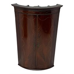 Late Georgian mahogany hanging corner cupboard, moulded cornice with interlaced boxwood stringing pattern above two cupboard doors inlaid with wave form boxwood stringing and four internal shelves 