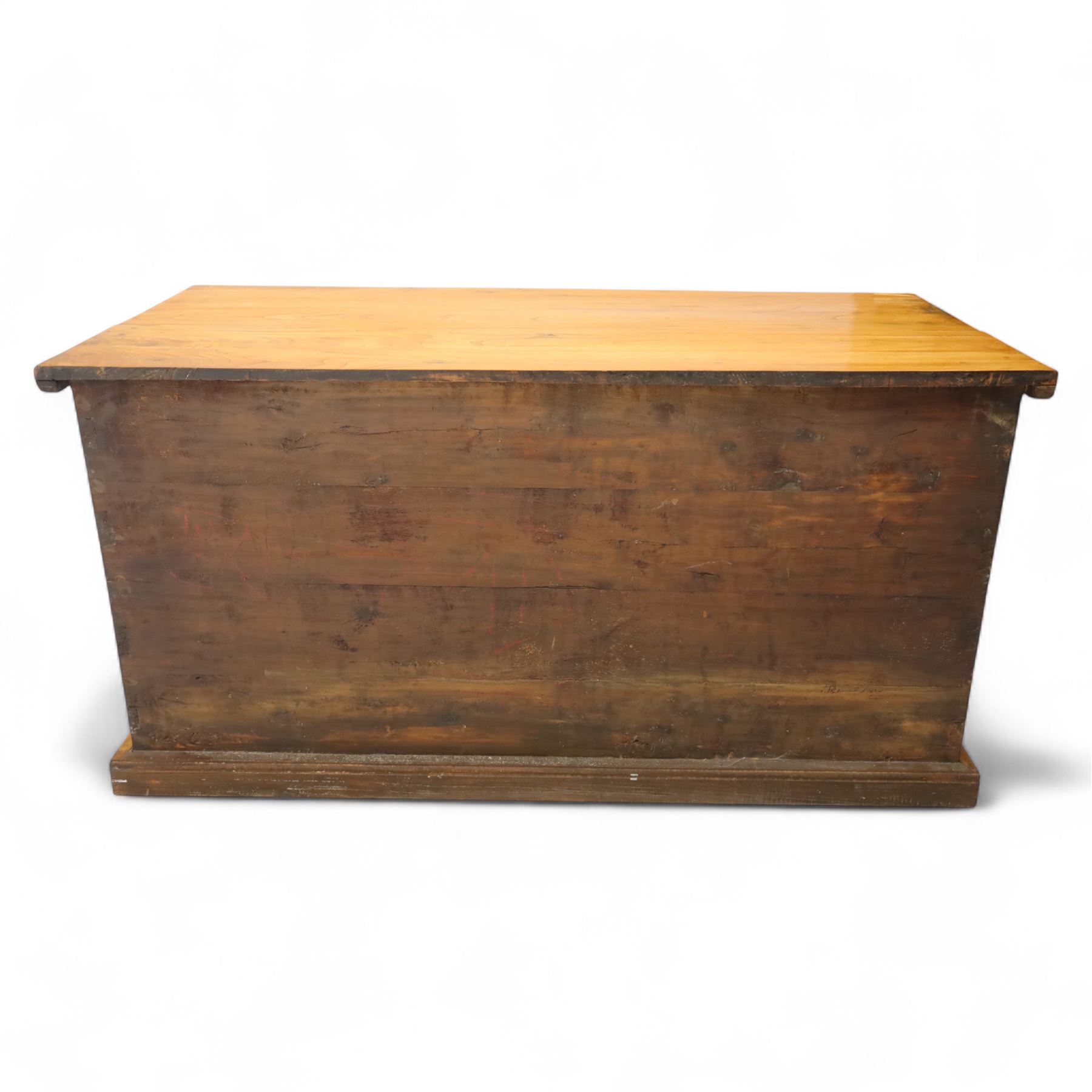 Burmese hardwood and brass inlaid marriage chest, the hinged top enclosing a fitted interior with small drawers, the front decorated with a circular brass medallion, raised on a plinth base