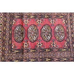 Four small Persian and Caucasian design rugs, comprising a Kazak rug with twin hooked medallions on a red ground, Baluchi rug with geometric motifs on a muted red ground, Shiraz rug with a central ivory and red medallion on a blue ground, and a Bokhara mat with four guls on a rose ground, each enclosed by geometric borders, largest 143cm x 88cm (4)