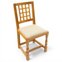 Knightman - eight oak dining chairs, the rectangular back with square section lattice splat enclosed by straight stiles and top rail, drop in upholstered seat in pale patterned fabric, raised on square section legs with chamfered detailing united by stretchers, with carved knight signature, by Horace Knight of Thirsk