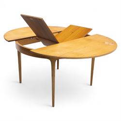 Sutcliffe of Todmorden - mid 20th century ‘S-Form’ teak dining table and chairs, the circular storable extending table with plain veneered top on tapered supports, together with matching dining chairs upholstered in black vinyl, with curved slat backs and shaped front supports, reflecting the sleek organic styling characteristic of 1960s British modern furniture design (Chairs H 93cm, W 46cm, D 46cm) (Extended 168cm)