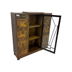 Art Deco burr walnut drinks cabinet, geometric central glazed astragal door enclosing two fixed shelves, flanked by symmetrical bookmatched veneered cupboards with drawers above 