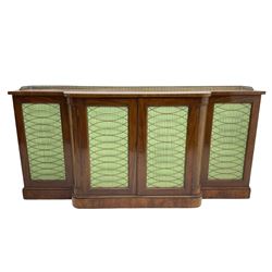 19th century mahogany break-front sideboard, raised brass gallery back with Greek key design, fitted with four cupboard doors, their pleated green fabric overlain with gilt metal grilles, lower moulded edge over plinth base