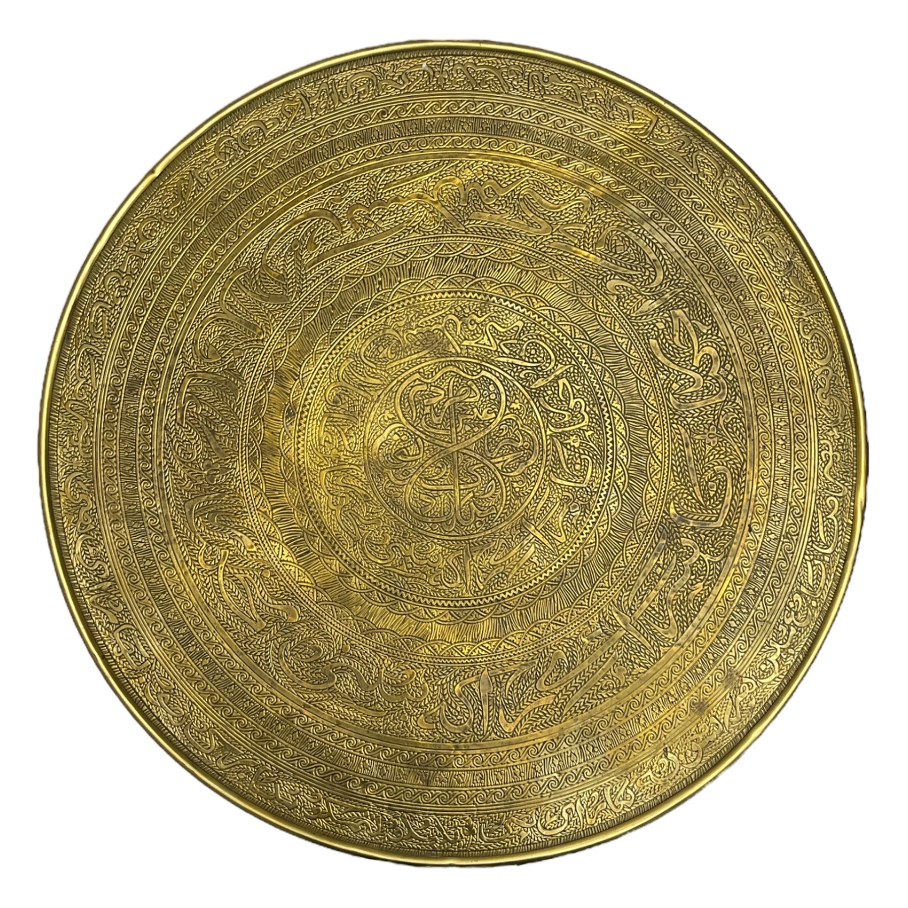 Indian brass topped folding benares table, circular top embossed with foliate and scrolling decoration, reeded supports