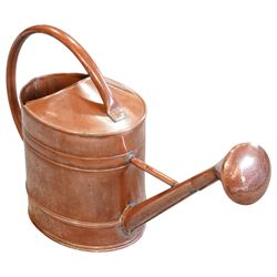 19th century copper watering can, with a looping handle and a rose to the end of the spout