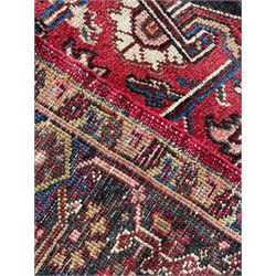 Persian Heriz red ground rug, large medallion decorated with palmettes and Ejder motifs, the border decorated with stylised plant motifs, within floral design guard stripes 