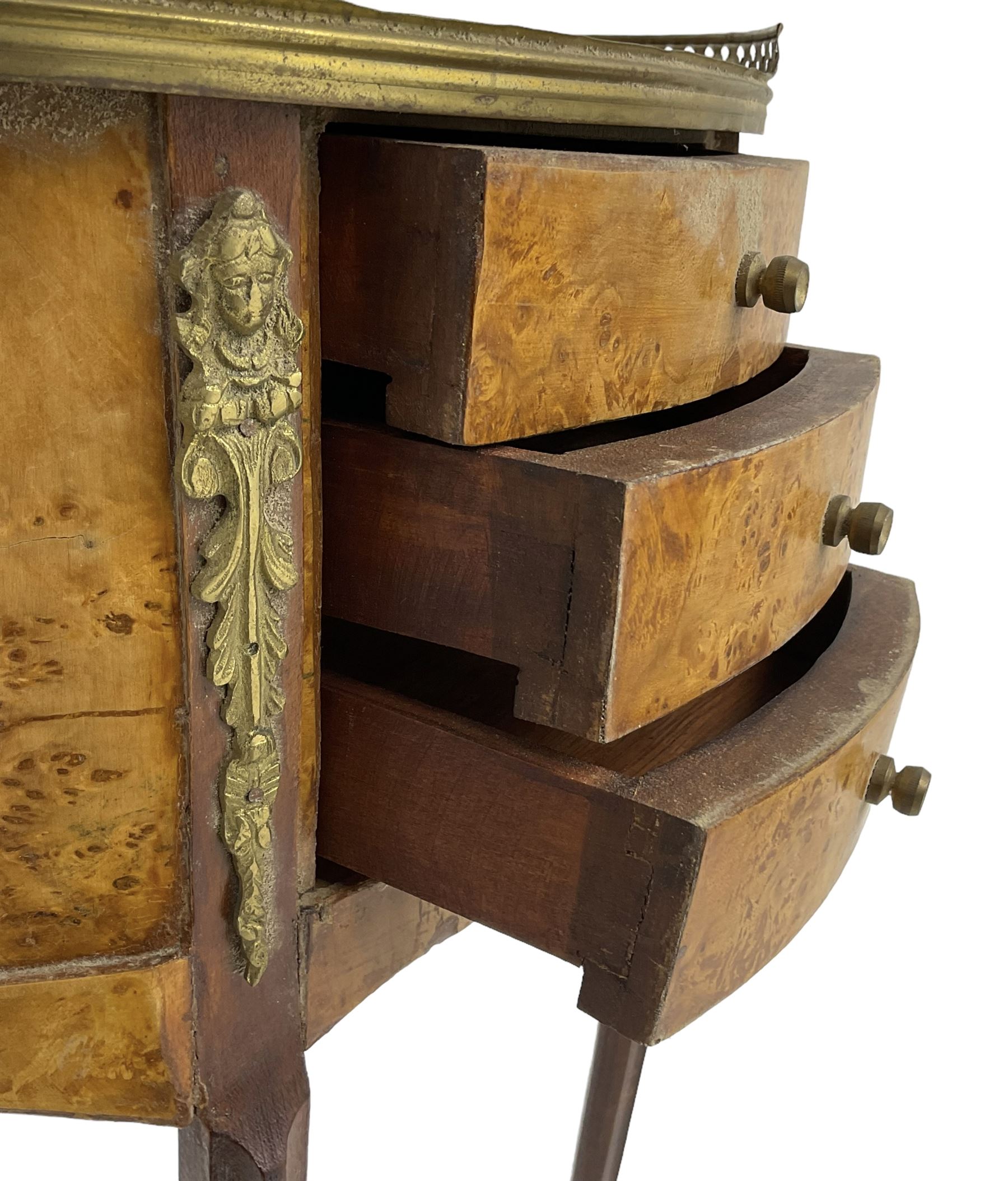 Late 20th century French design figured elm and bedside table, raised pierced gilt metal gallery over oval top, fitted with three mahogany lined drawers flanked by gilt metal mounts of female mask and foliate form, on cabriole supports