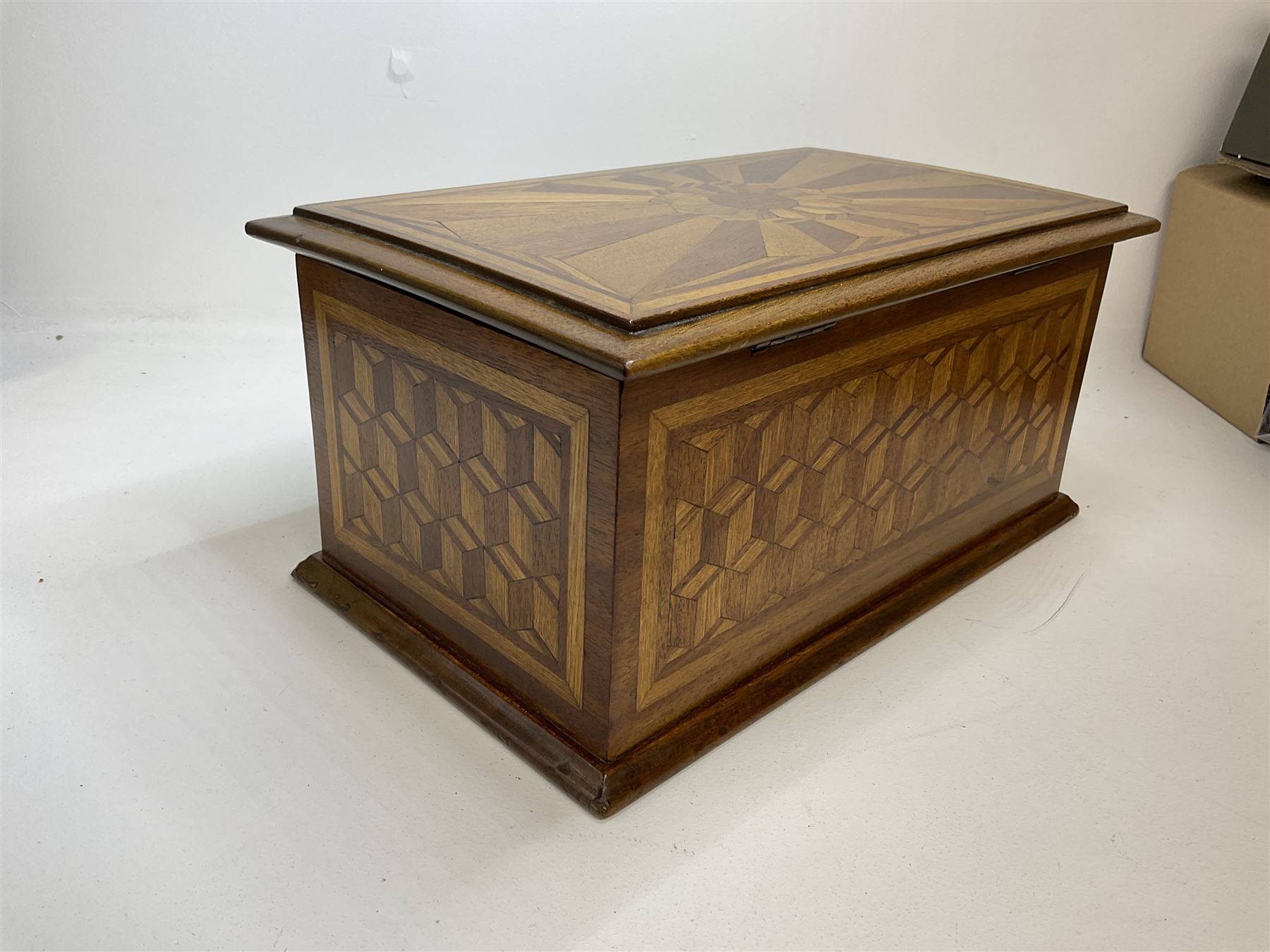 19th Century mahogany and parquetry box of rectangular form, geometric cube design, with a stylised sun detail to the hinged cover, opening to reveal three compartments, L33cm D21cm H16cm
