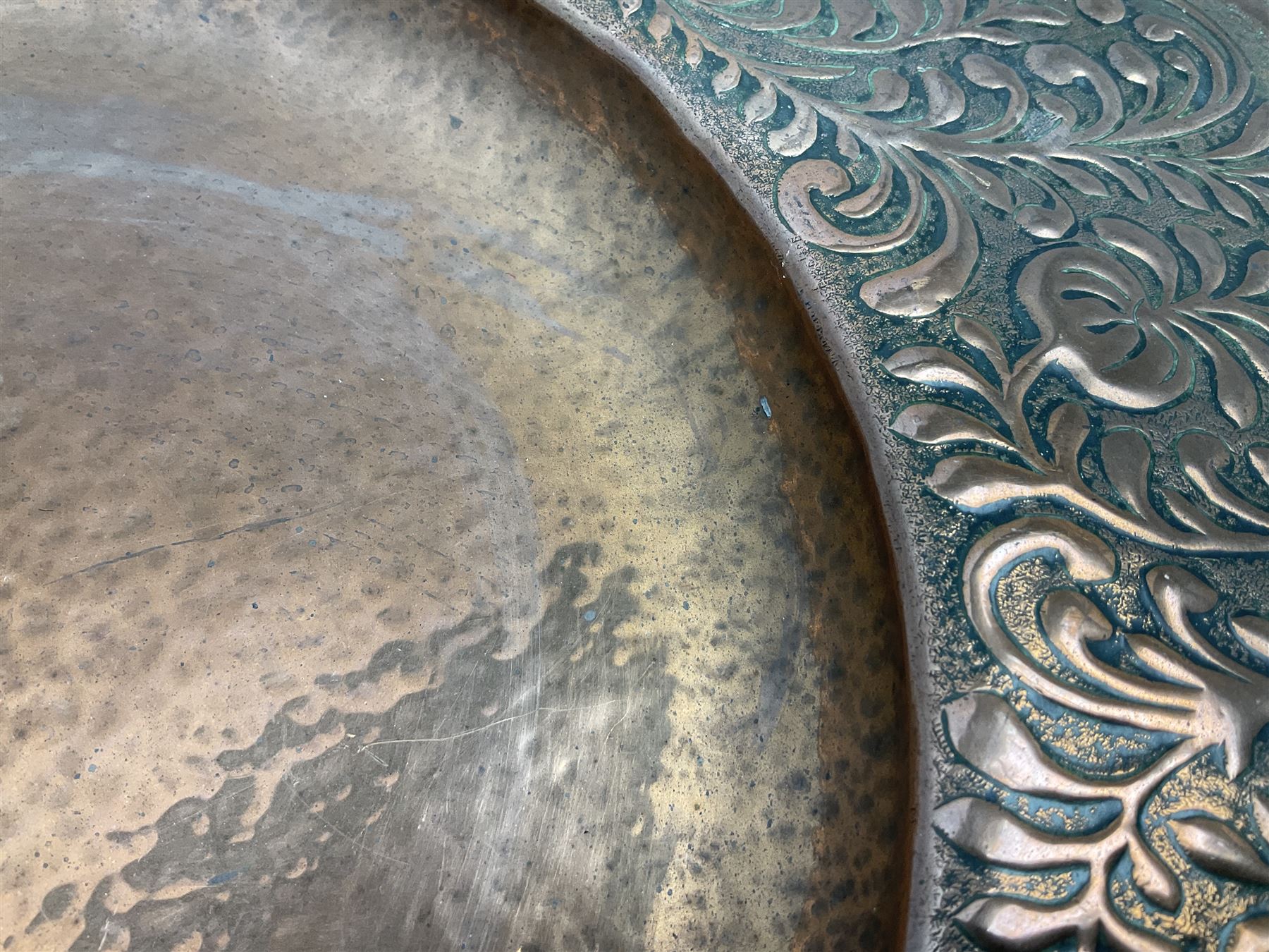 Arts and Crafts Keswick School of Industrial Arts copper charger, decorated with planished centre and repousse scrolling foliate tendrils to rim, D44cm