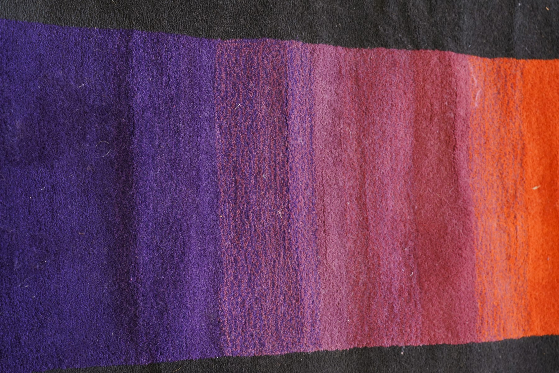 Contemporary wool runner rug, the field in a vibrant vibrant sunset-to-purple gradient with a wide dark indigo guard band