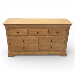 Contemporary oak veneered sideboard, moulded rectangular top above a six drawer arrangement, three over three, each drawer with turned ebonised style knob handle, panelled ends, raised on a shaped plinth base with bracket feet