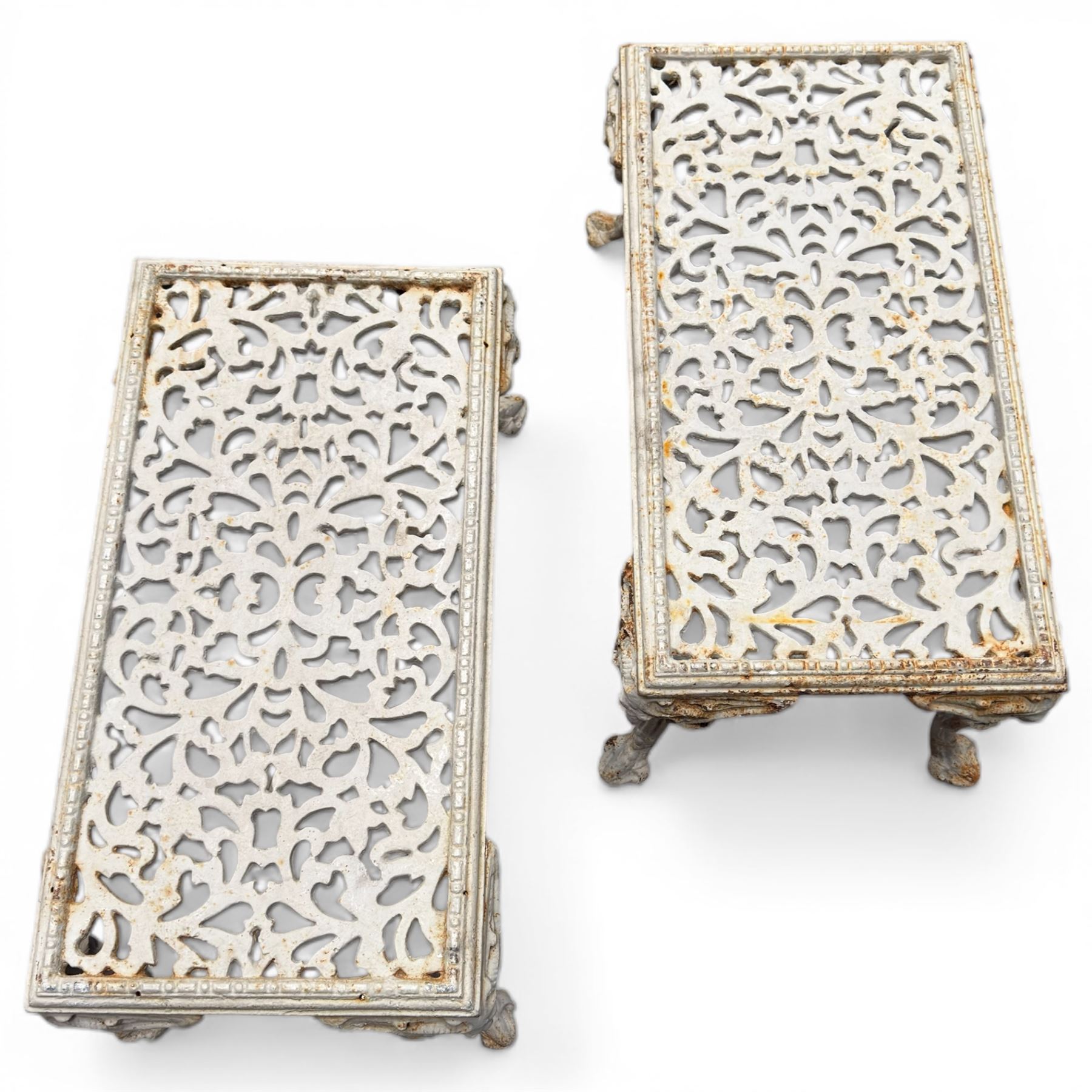 Pair of cast iron low garden tables with rams head legs in a white finish